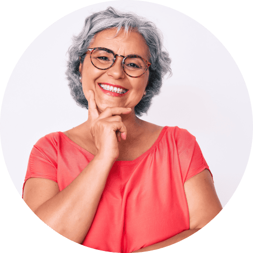 Middle-aged woman with salt and pepper hair, brown eyes, and glasses smiles.